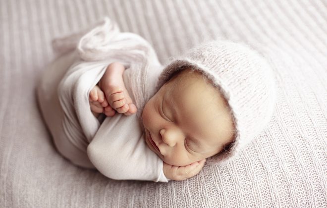 sleepy smiling wrapped newborn