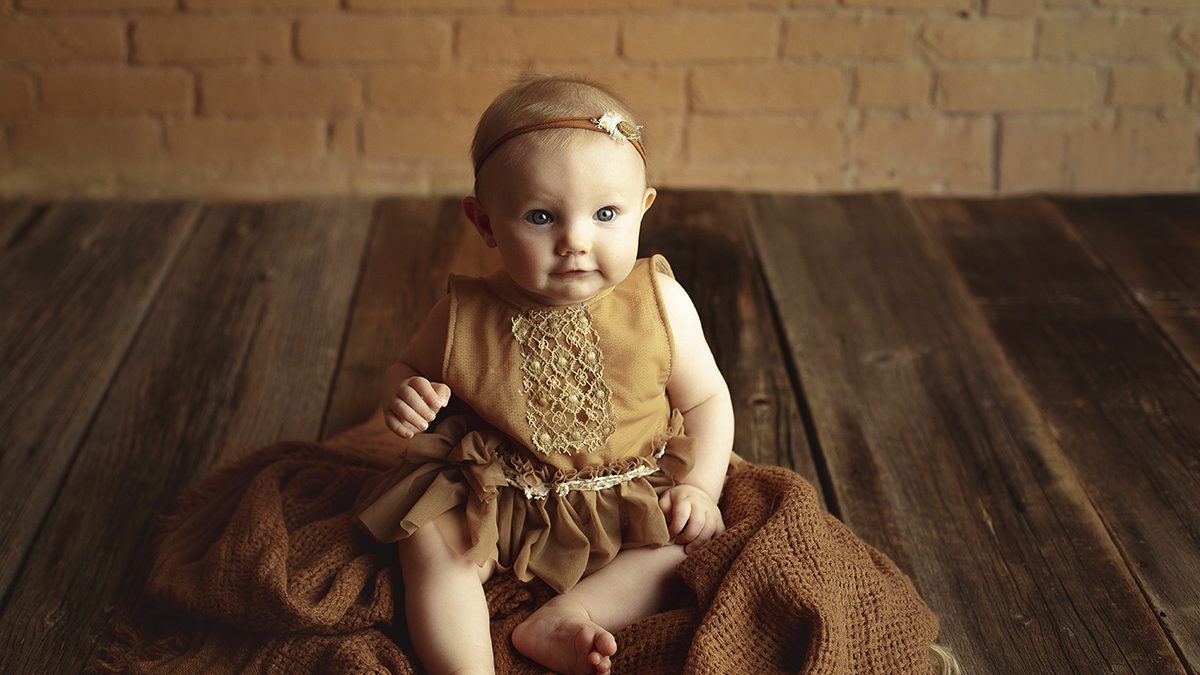 smiling 6 month old baby girl with warm earthtones