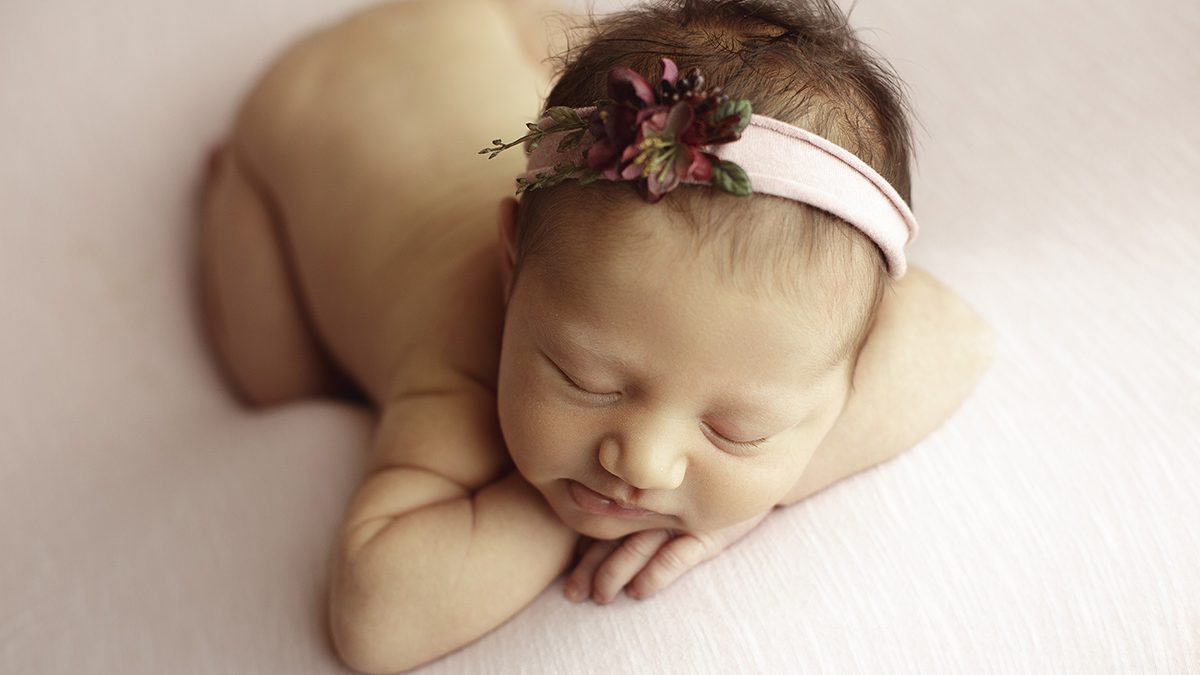 newborn girl on soft pink backdrop