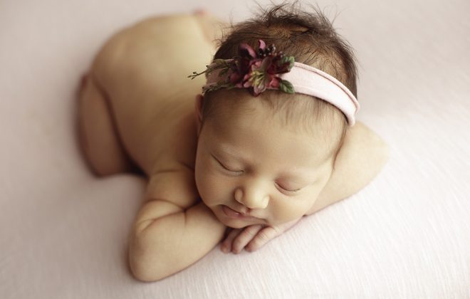 newborn girl on soft pink backdrop