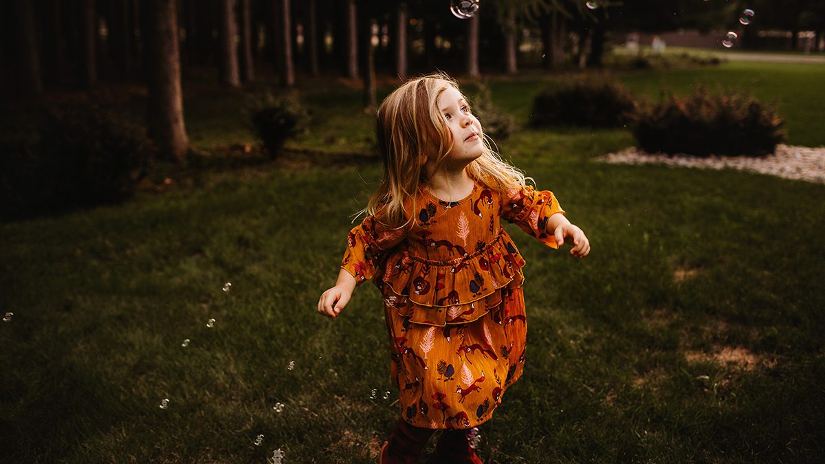 girl chasing bubbles during photo session