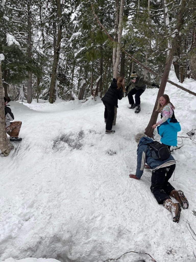 4 kids and an adult struggling to climb an icy hill in Michigan's upper peninsula