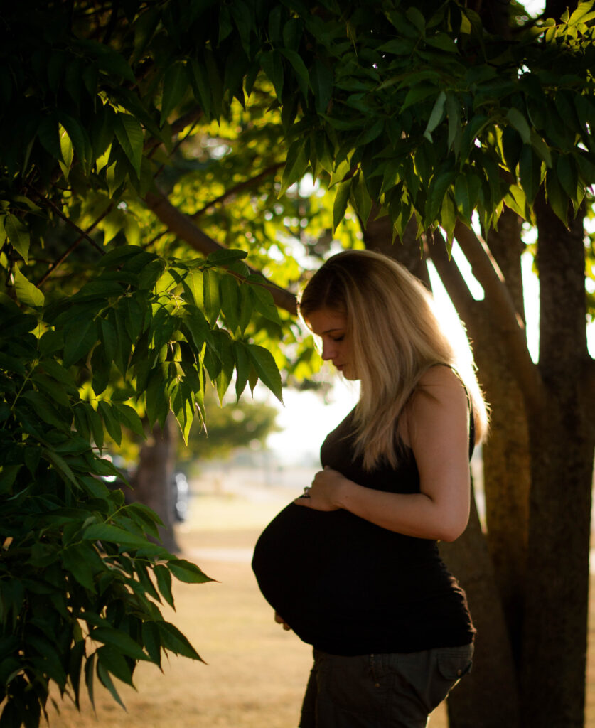 maternity self portrait of mom gazing down at her belly